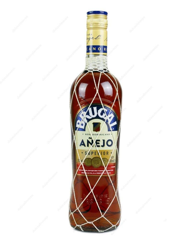 Botella de Ron Brugal Añejo 0.70L con su característica malla de red dorada - Dulcealmacen