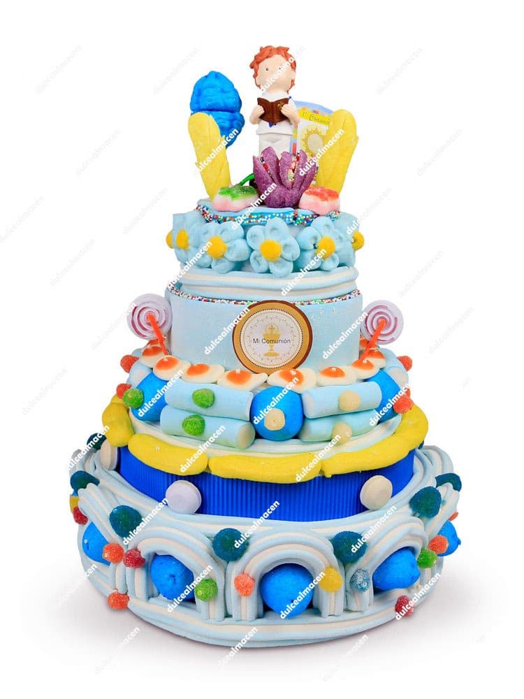 Tarta de chuches artesanal para comunión con varios niveles, nubes rosas y blancas, gominolas variadas y figura de niño de comunión en la parte superior - Dulcealmacen